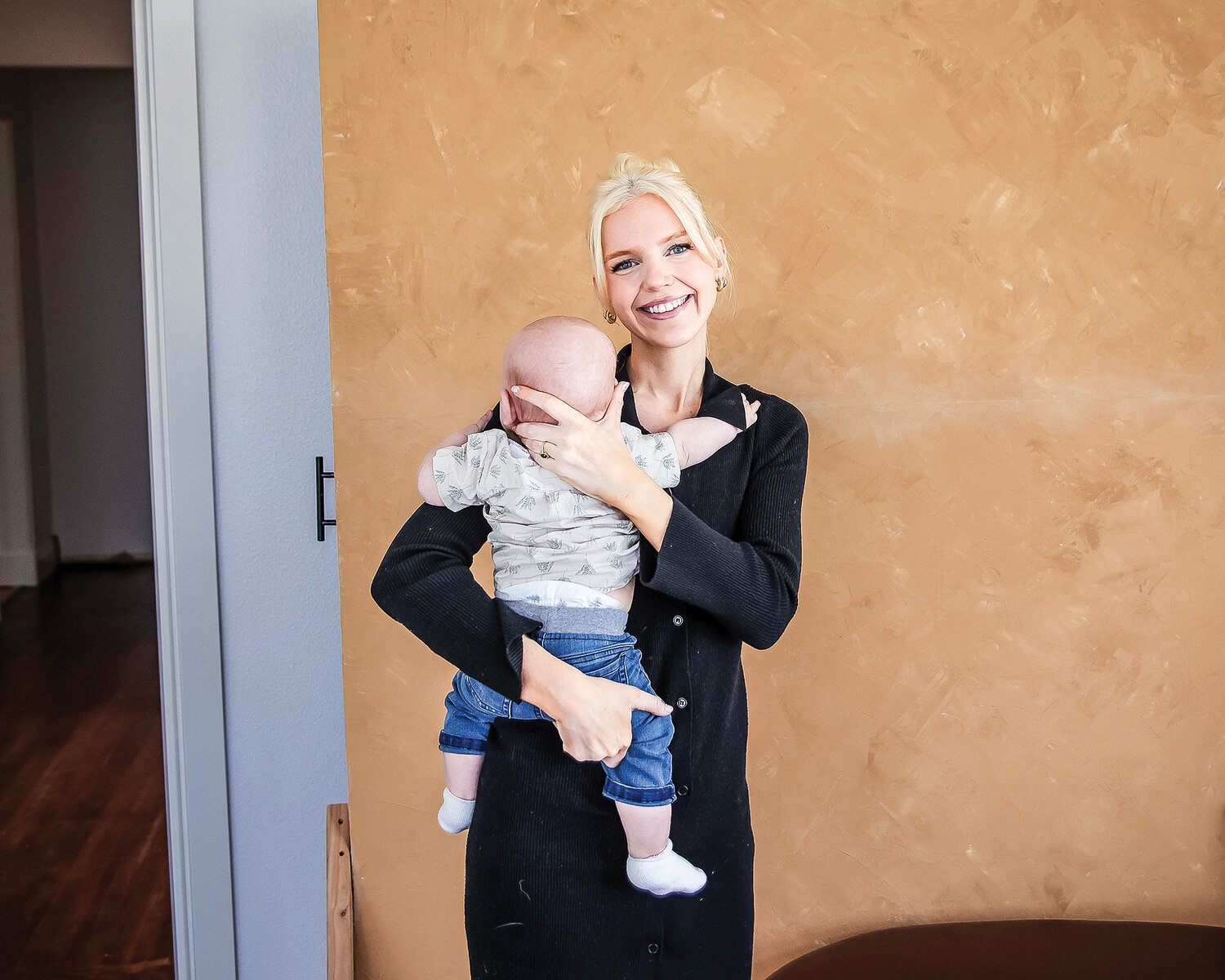 Em LeFrancq holds her child, Monroe, in front of a photo studio backdrop at Louie Jean Studios on Wednesday, May 3. Em LeFrancq owns the new photo studio and event space in Woodland with her husband, Carson LeFrancq.