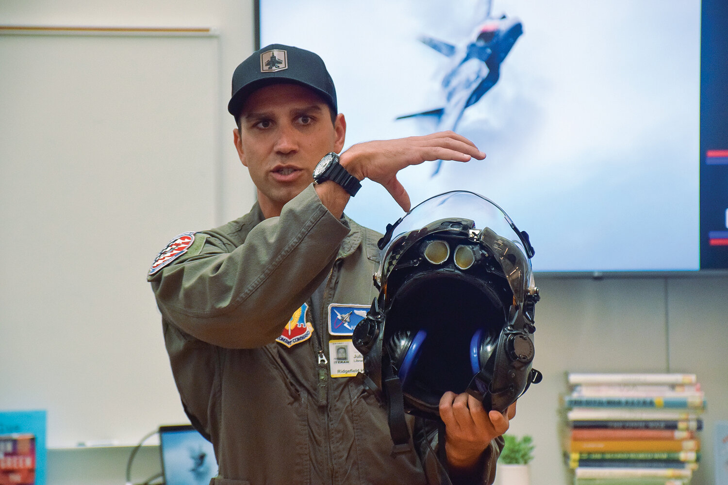 U.S. Air Force Capt. Julian Kinonen shows off the helmet for the F-35A Lightning II fighter jet to students at Ridgefield High School on May 18.