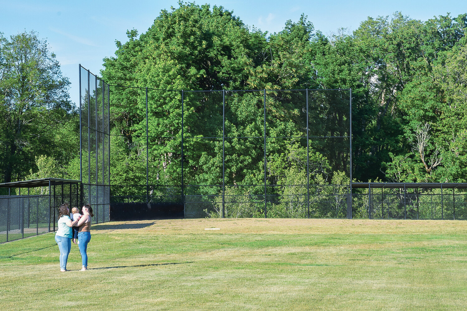Attendees at the open house for Woodland’s Scott Hill Park stand in front of the completed structure for a softball and little league field on May 18.