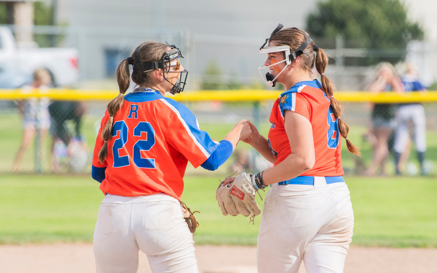 Ridgefield’s Madison Walker (22) talks with pitcher Elizabeth Peery (8) during a state title game against North Kitsap at Carlon Park in Selah on Saturday, May 27.