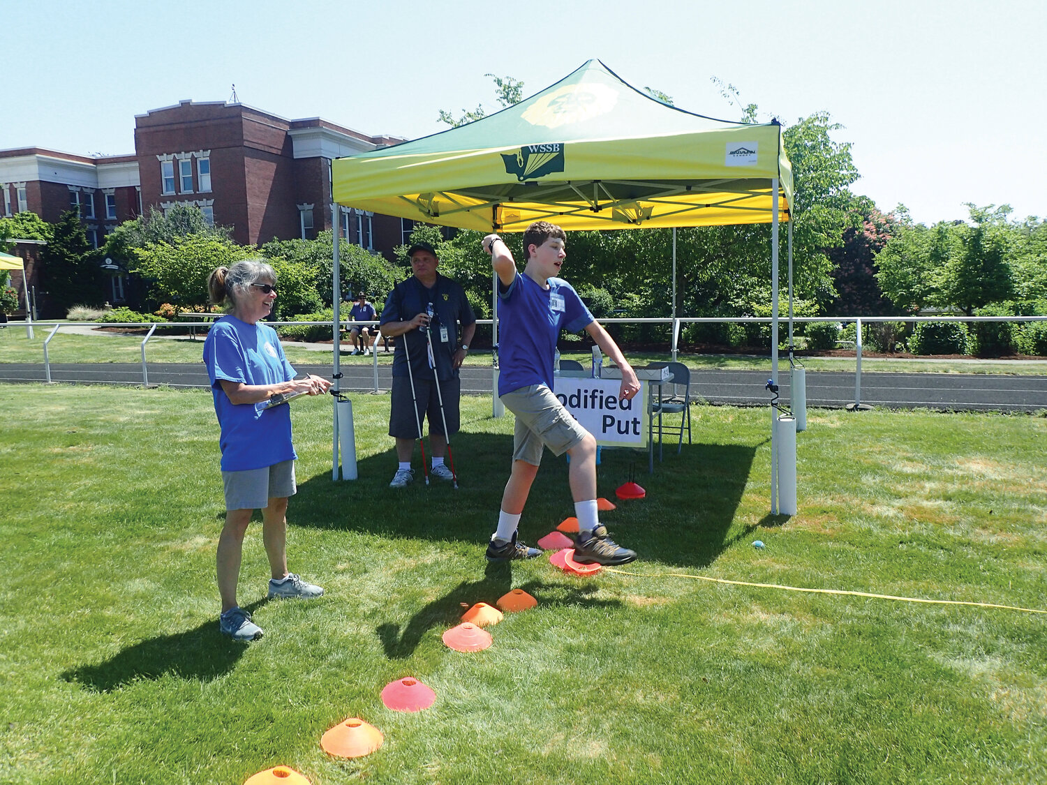 Ridgefield Lions Club member Roxanne Cortez assists at the modified shot put while athlete Eric Bickford participates at the Washington State School for the Blind’s annual track and field day on May 18.