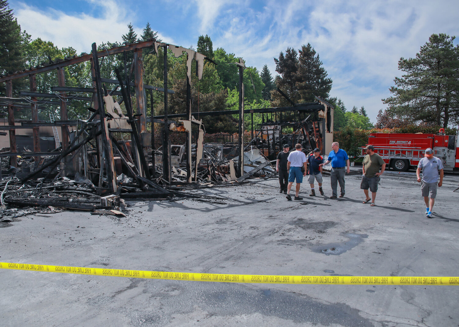 Fire crews and investigators remained on scene on Wednesday, June 7, as business owners and employees walked around the scene of the two-alarm industrial building fire in Salmon Creek.