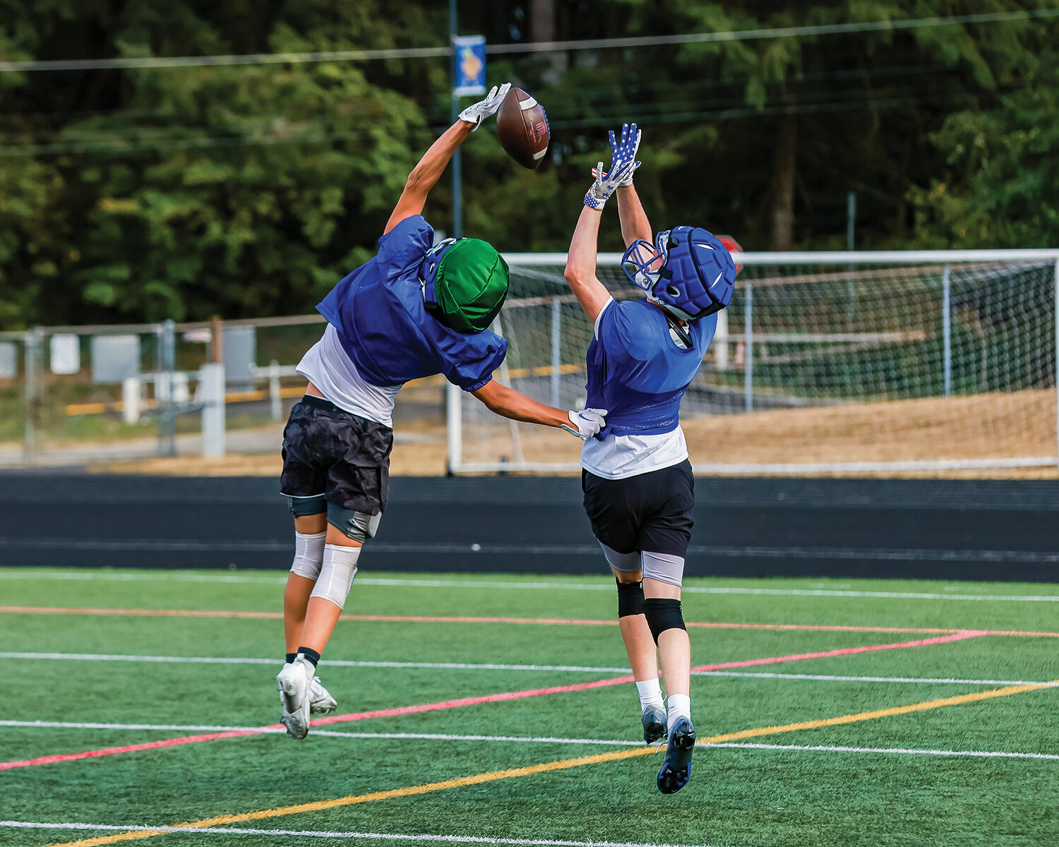 A Ridgefield Spudder deflects a pass against his teammate in a scrimmage drill on Tuesday, Aug. 22.