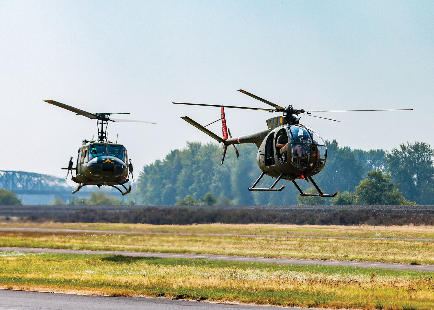 A Hughes OH-6 Cayuse “Loach” and a Bell UH-1 Iroquois “Huey” come in for a landing at the Southwest Washington Regional Airport for the third annual fly-in event at Cascade Air in Kelso on Sunday, Aug. 27. The aircraft are from The National Wings and Armor Foundation out of North Clark County.