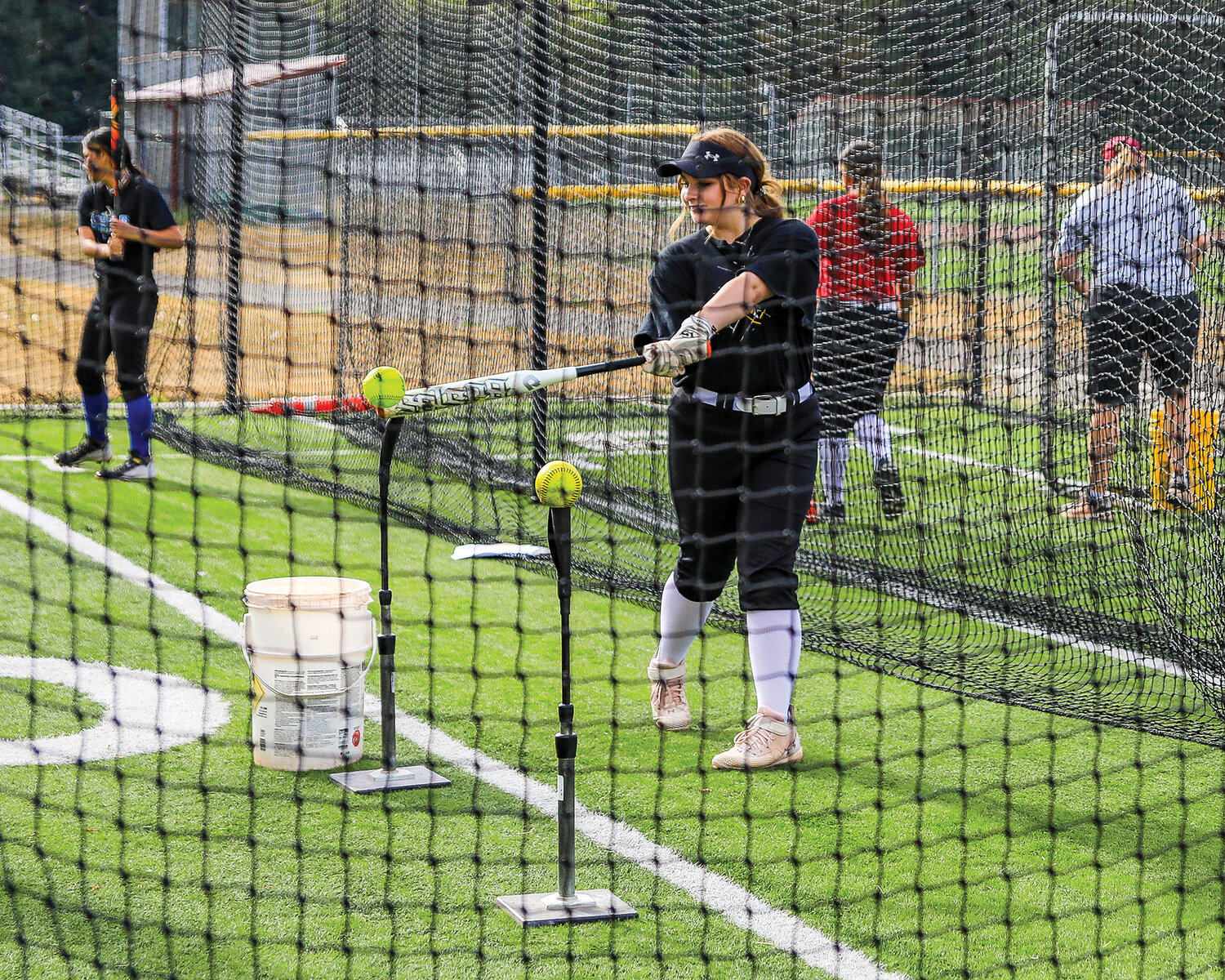 Players for the Prairie High School slow pitch softball team participate in a 10-station hitting drill during practice on Wednesday, Aug. 30.