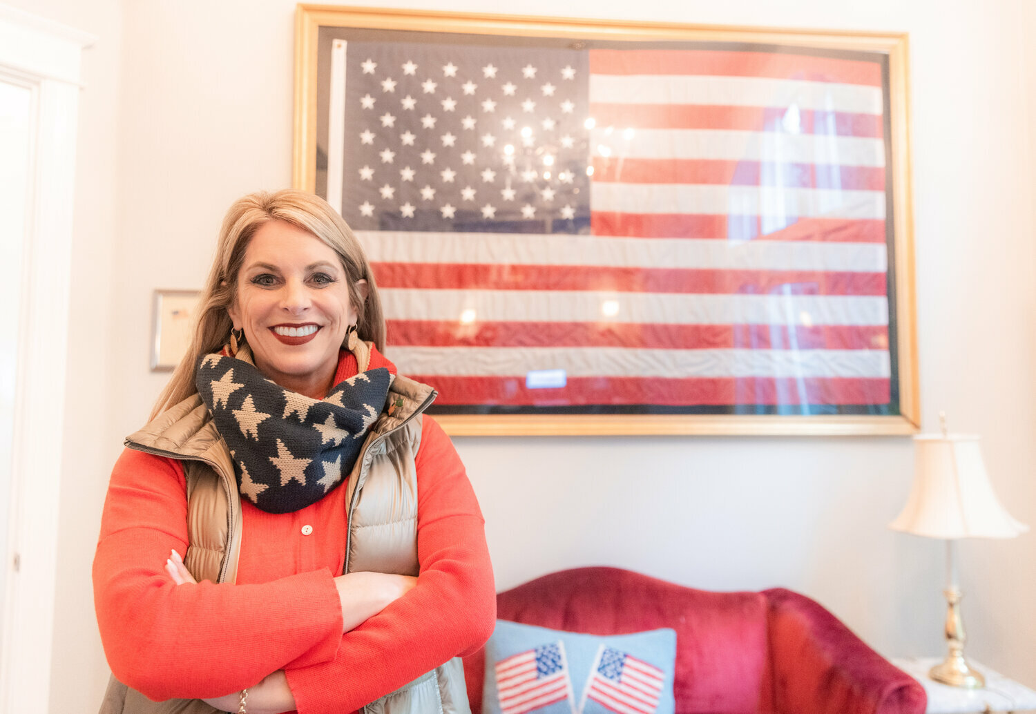 Leslie Lewallen smiles for a photo in front of a flag that flew over the White House at her Camas home.