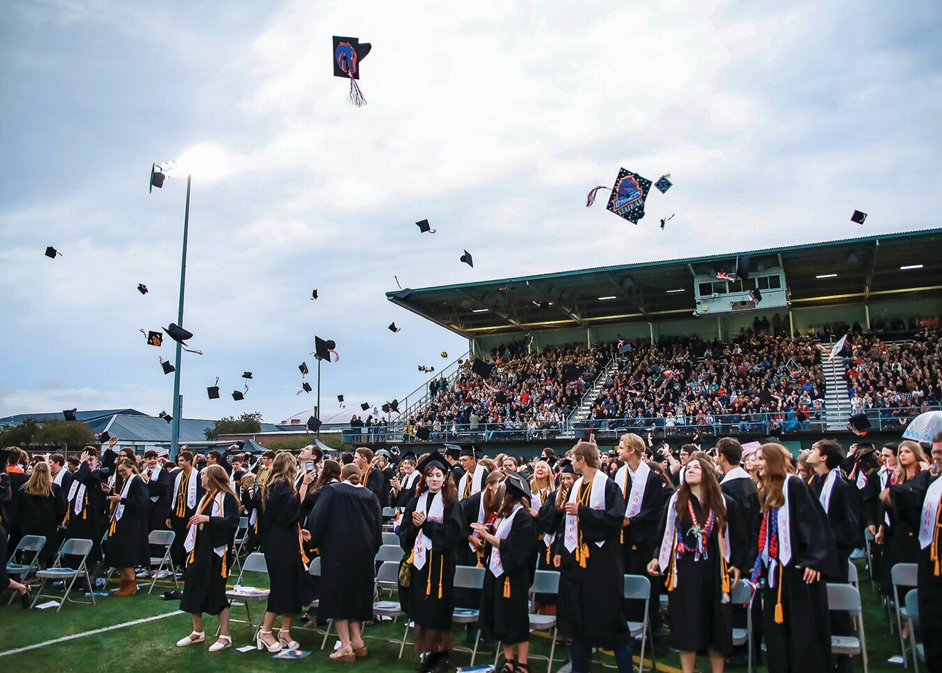 Battle Ground High School students throw their caps during their graduation ceremony this June. Battle Ground Public Schools was approved to receive a five-year, $5 million federal grant to improve mental health services and hire intervention coordinators at both Battle Ground and Prairie high schools this year.