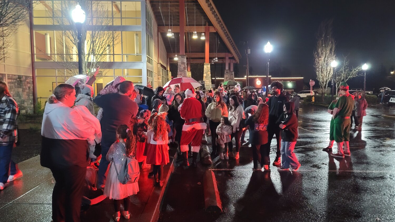 Santa Claus is illuminated in red on his ride, a Clark County Fire District 3 truck, to the Battle Ground Community Center. Mrs. Claus rode in with the Battle Ground Police Department for the tree-lighting ceremony on Friday, Dec. 1.