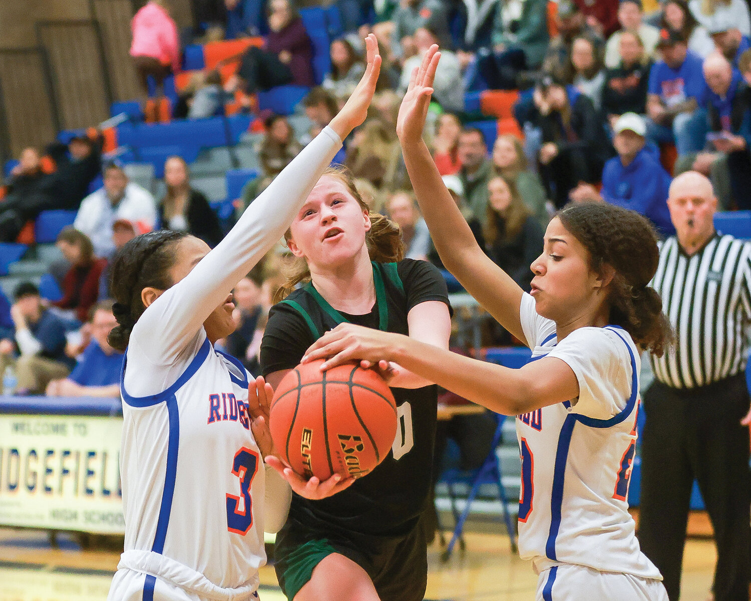 Ridgefield’s Savannah Chanda, left, and Jalise Chatman block a shot attempt by Woodland’s Addi Stading during the Spudders’ 60-35 win on Tuesday, Jan. 9.