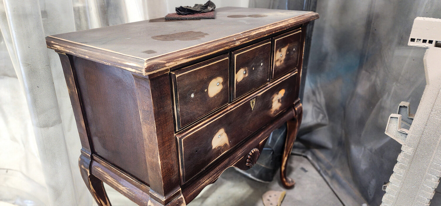 A well-worn antique side table awaits its restoration at Furniture on 5th.